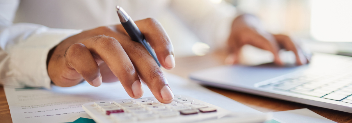 Finance, accounting and fintech, a man on a computer and calculator working out his business budget strategy. Businessman at his office desk, laptop, money management and financial investment online.