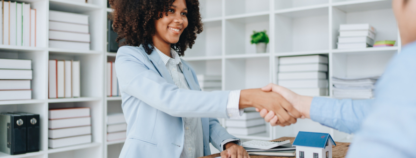 The bank's Female African american Mortgage Officers shake hands with customers to congratulate them after signing a housing investment loan agreement.