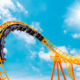 Roller coaster loop with blue sky and sunburst